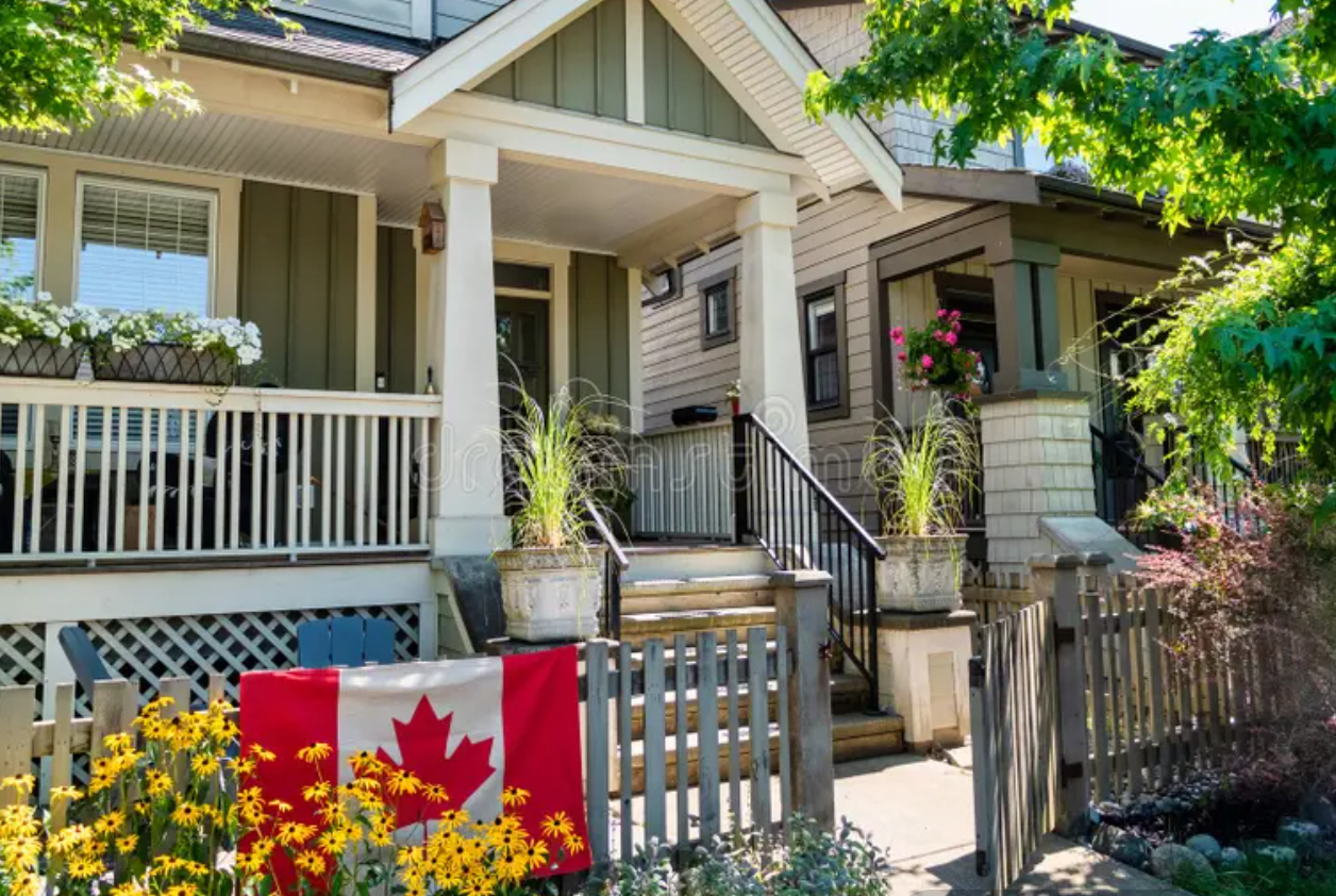 A Canadian family home with a Canadian flag on the porch, the kind of asset a personal guarantee can put at risk