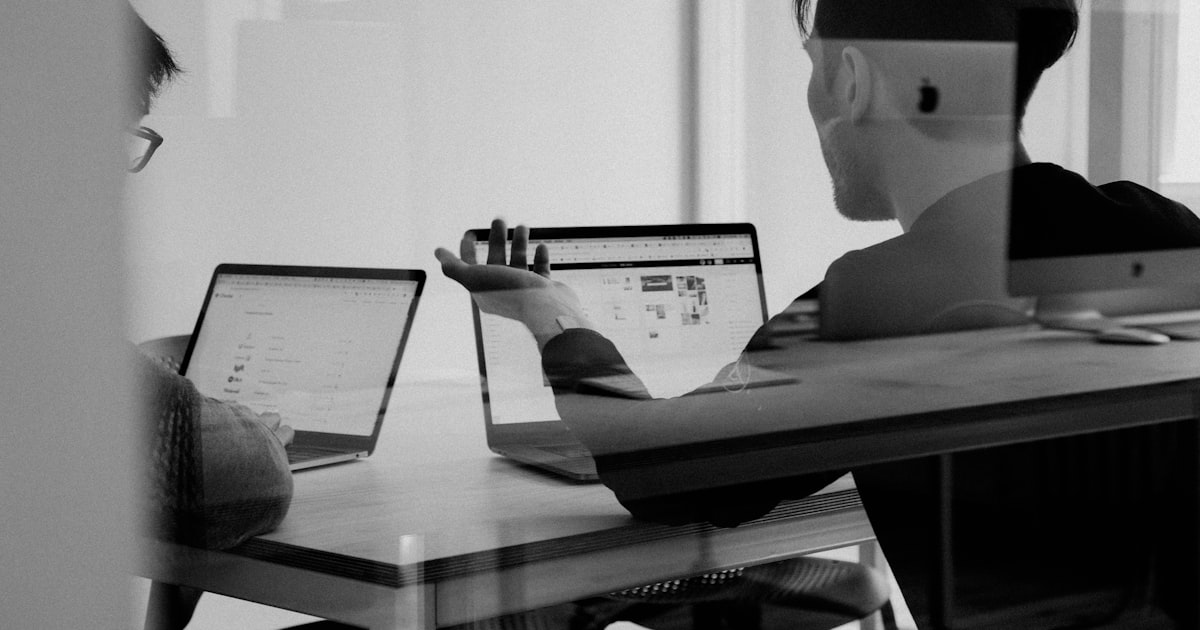 Advisor consulting a business owner client at a modern office desk