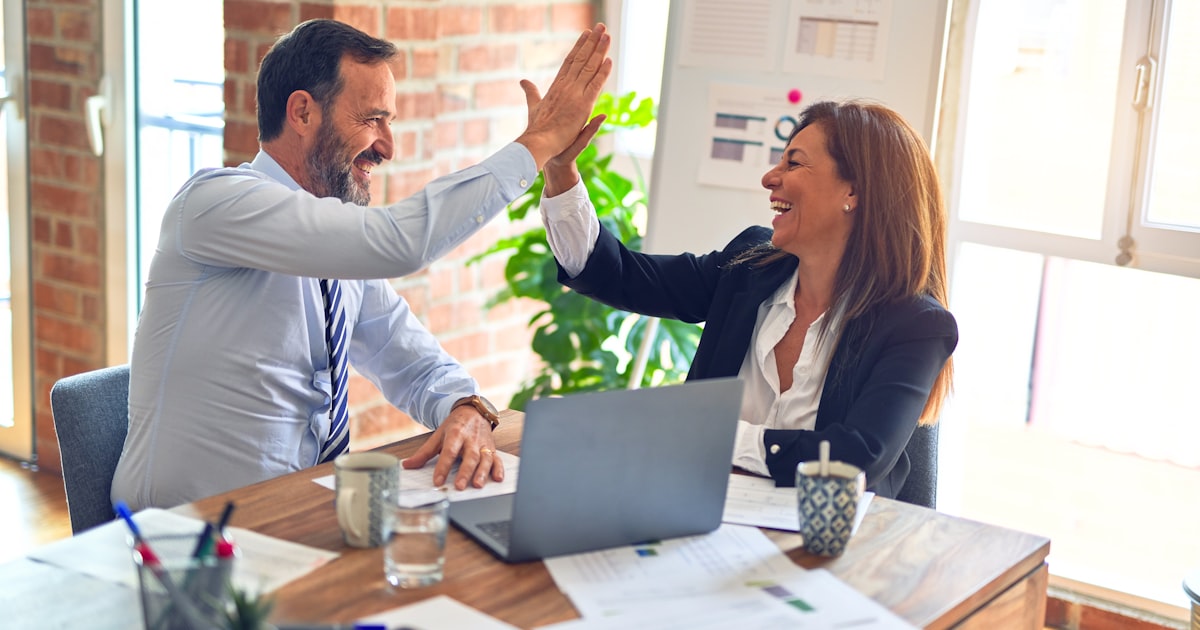 Advisor and client in mid-discussion across a modern office desk