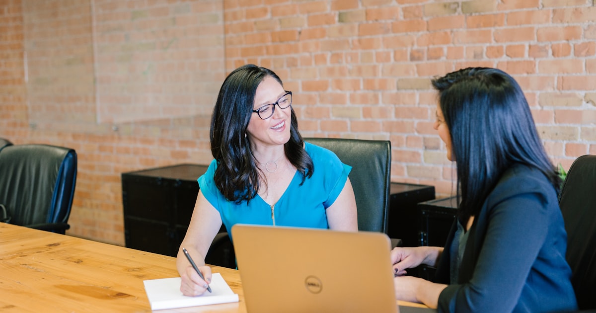 Two professionals comparing financing options at a modern conference table