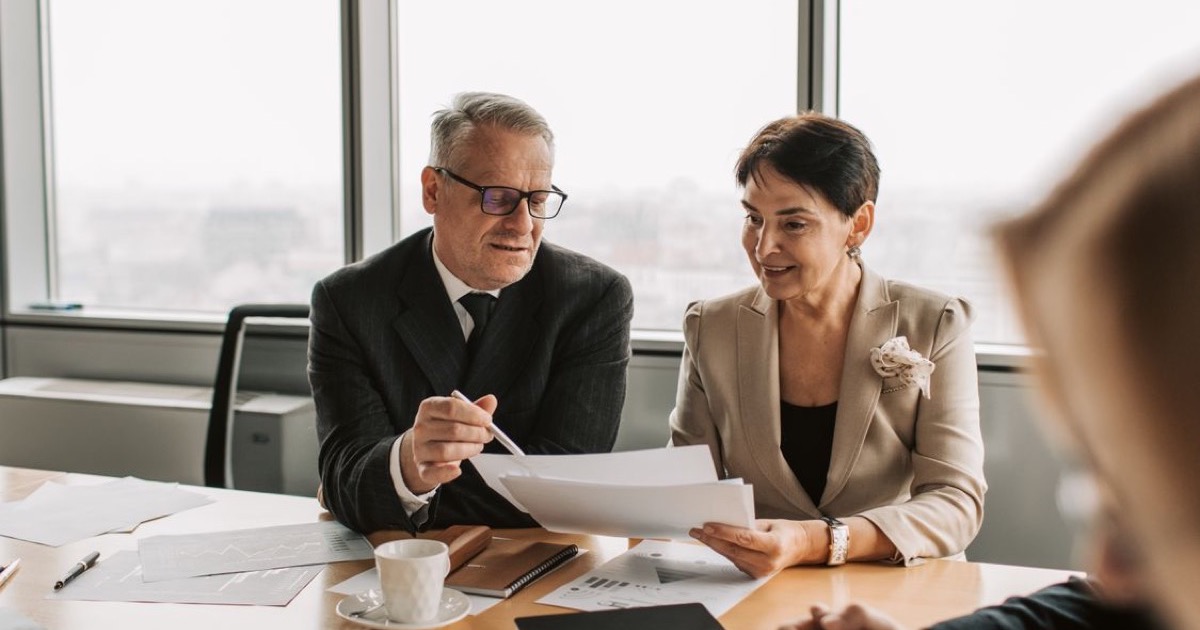 Acquisition buyer reviewing closing documents with an advisor at a conference table